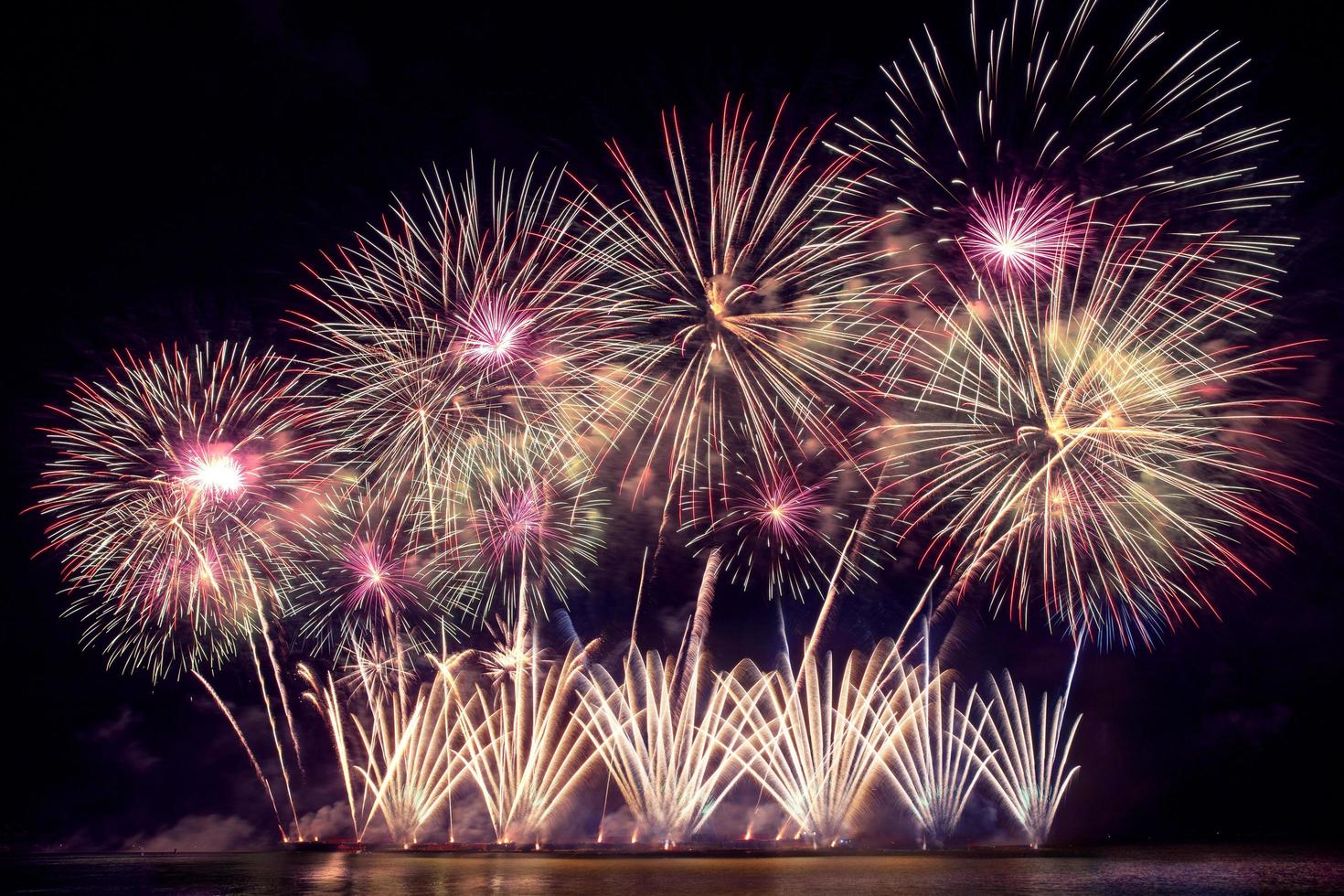 festliche schöne bunte Feuerwerkanzeige am Meeresstrand erstaunliche Feiertagsfeuerwerksparty oder jedes Festereignis im dunklen Himmel foto