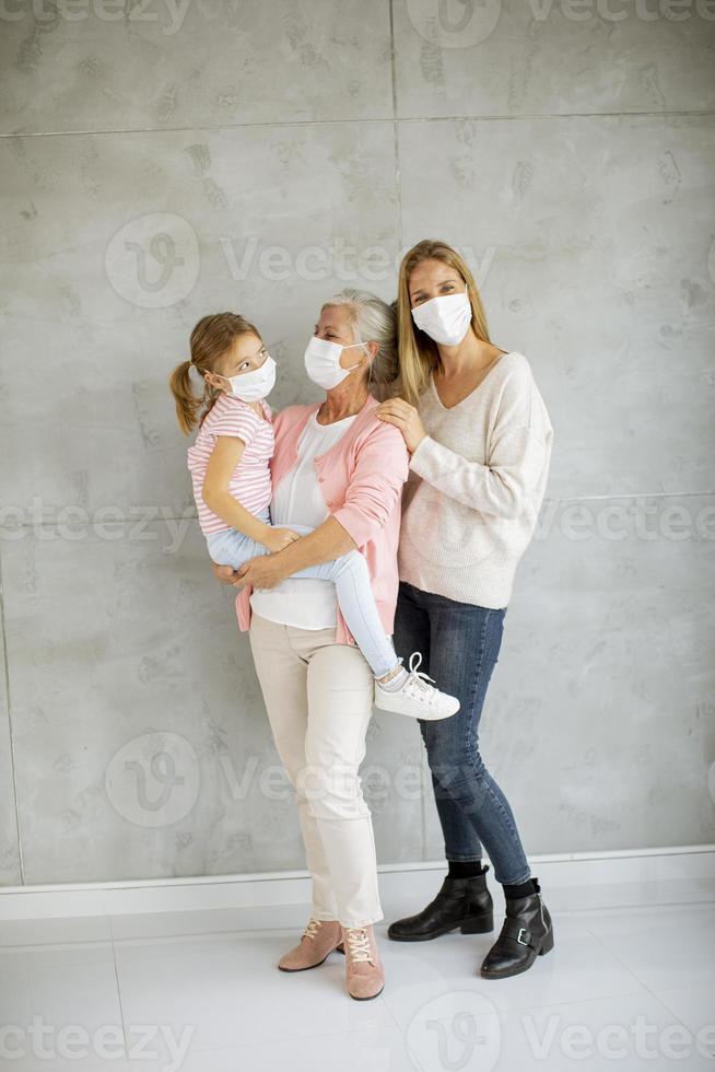 vertikale Ansicht eines Kindes, der Mutter und der Großmutter, die Masken tragen foto