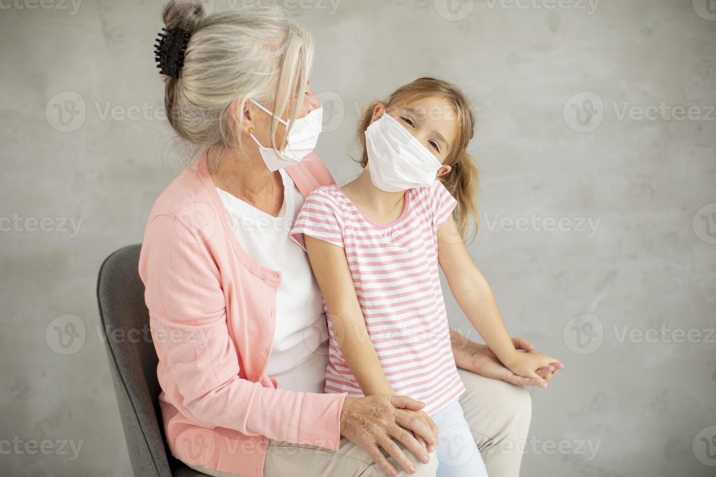 Großmutter und Enkelin tragen Masken foto