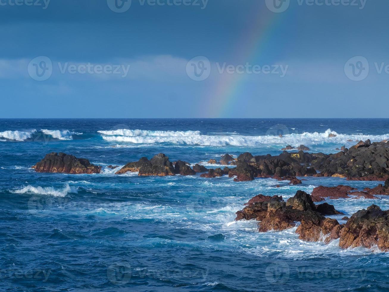 Atlantische Wellen und ein Regenbogen am felsigen Ufer der Kanarischen Inseln Puerto de la Cruz Tenerife foto