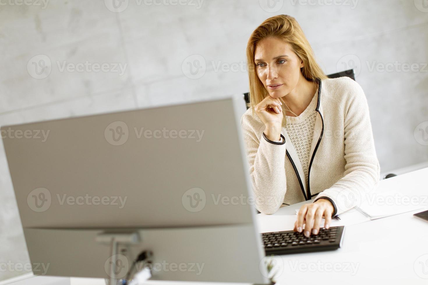 Geschäftsfrau, die an einem Computer arbeitet foto