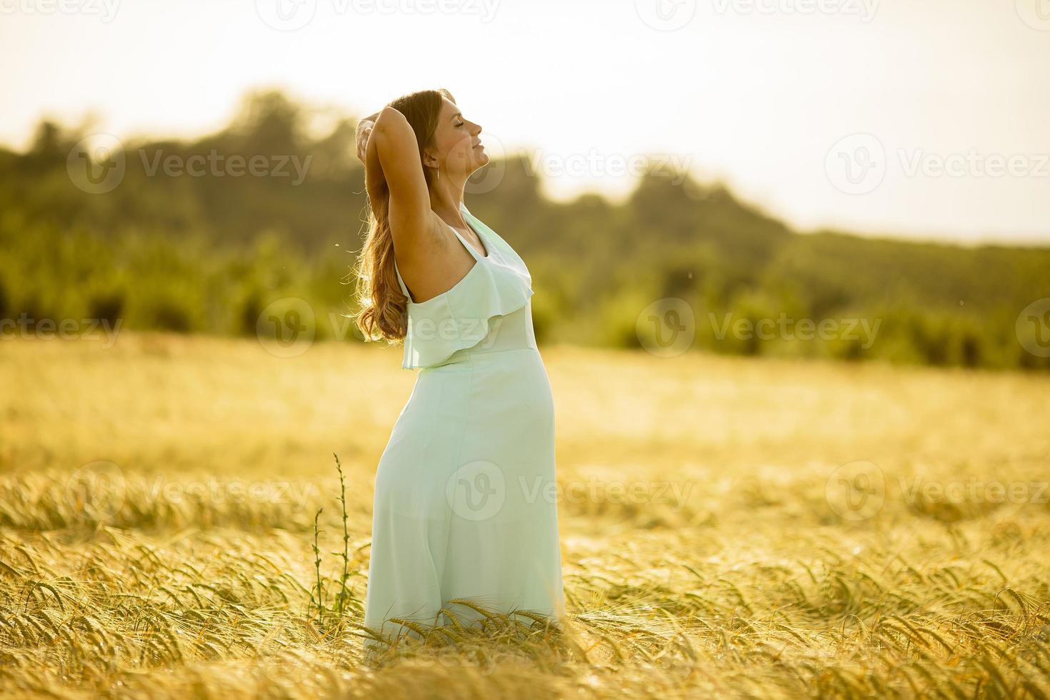 schwangere Frau posierte auf einem Feld foto