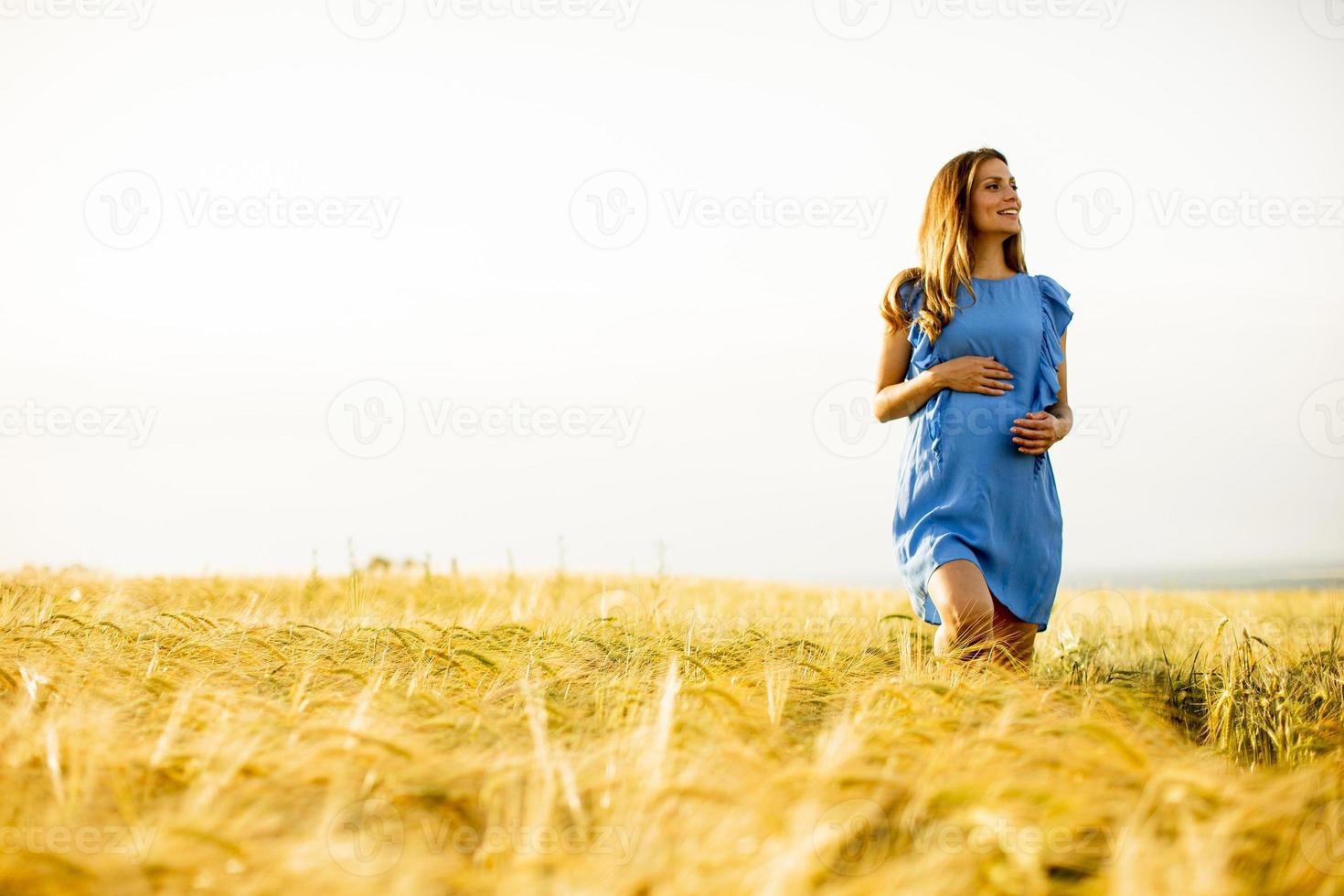 schwangere Frau im blauen Kleid mit Kopienraum foto