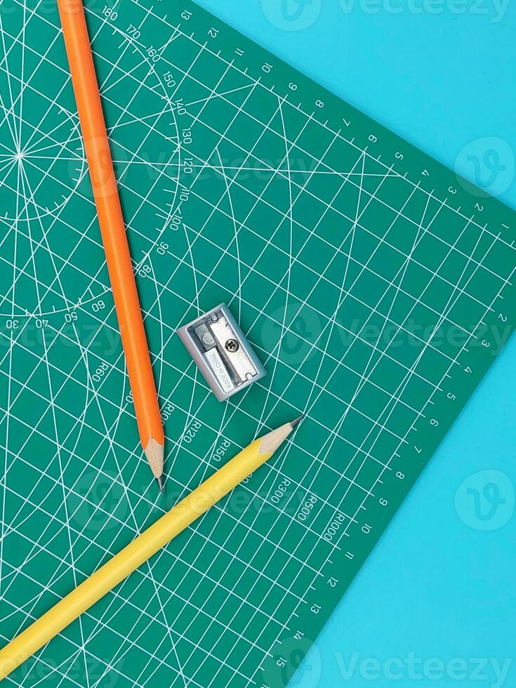 Grün Schneiden Matten , Stift Zeichnungen , einstellen Winkel Werkzeug , Rahmen Lineal auf Blau Hintergrund foto