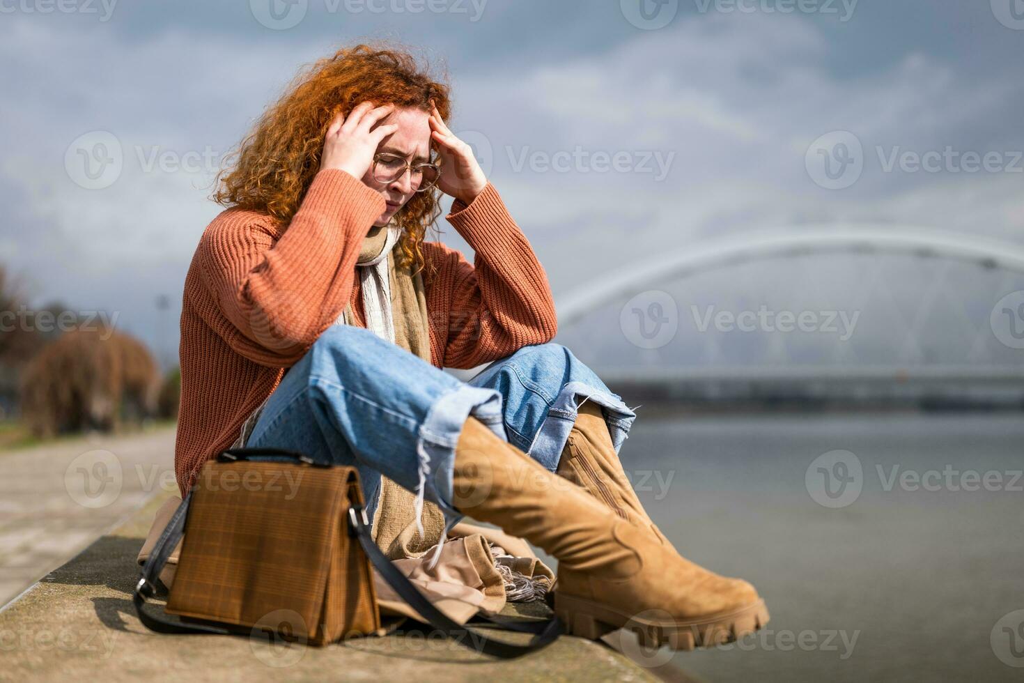 natürlich Porträt von ein kaukasisch Ingwer Frau mit Sommersprossen und lockig Haar. sie ist müde und entspannend draussen nach arbeiten. foto