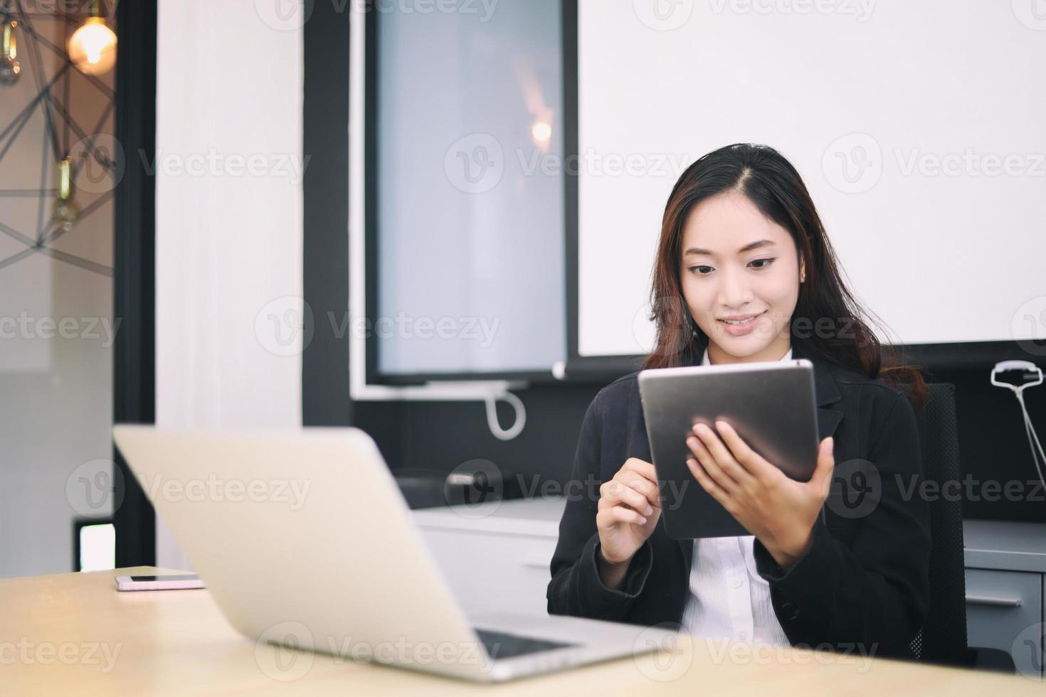 Frau im Büro mit digitalem Tablet foto