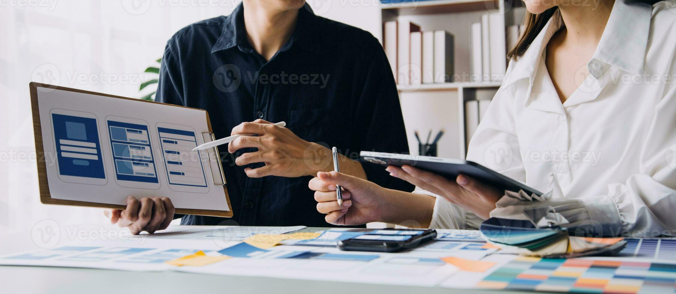 Nahaufnahme von UX-Entwicklern und UI-Designern beim Brainstorming über das Wireframe-Design der mobilen App-Schnittstelle auf dem Tisch mit Kundeninformationen und Farbcode in der Agentur für moderne digitale Entwicklung von Office.Creative foto