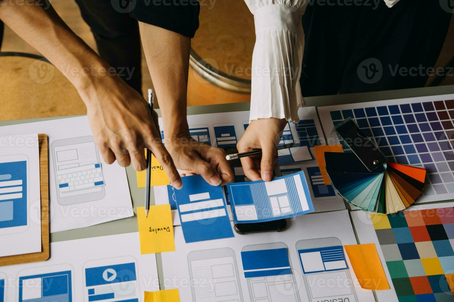 Nahaufnahme von UX-Entwicklern und UI-Designern beim Brainstorming über das Wireframe-Design der mobilen App-Schnittstelle auf dem Tisch mit Kundeninformationen und Farbcode in der Agentur für moderne digitale Entwicklung von Office.Creative foto