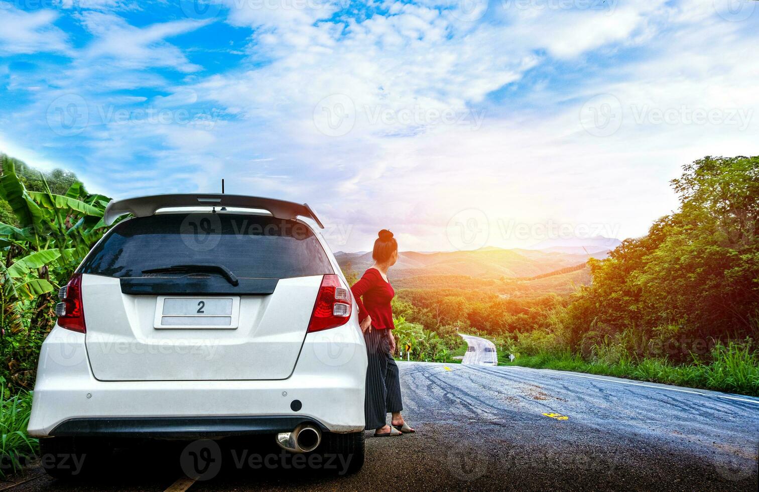 junge schöne Dame, die nahe gebrochenem Auto steht und um Hilfe auf der öffentlichen Straße in einem Waldgebiet ruft foto