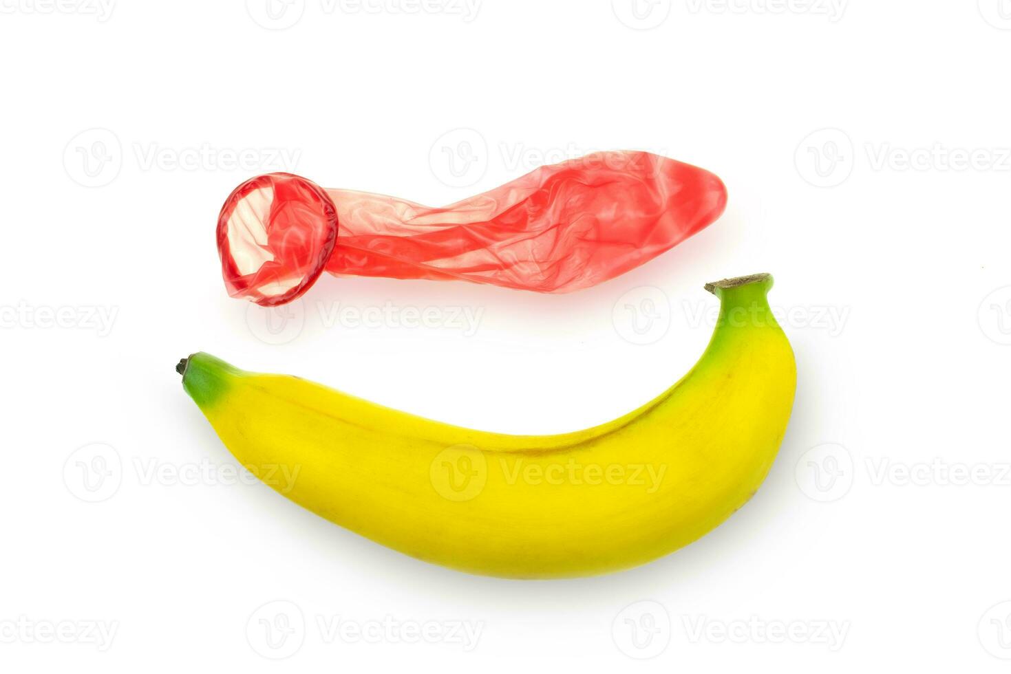 rotes Kondom getragen auf einer Banane auf einem weißen Hintergrund foto