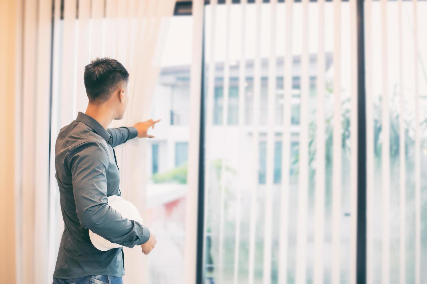 Mann, der aus dem Fenster schaut foto