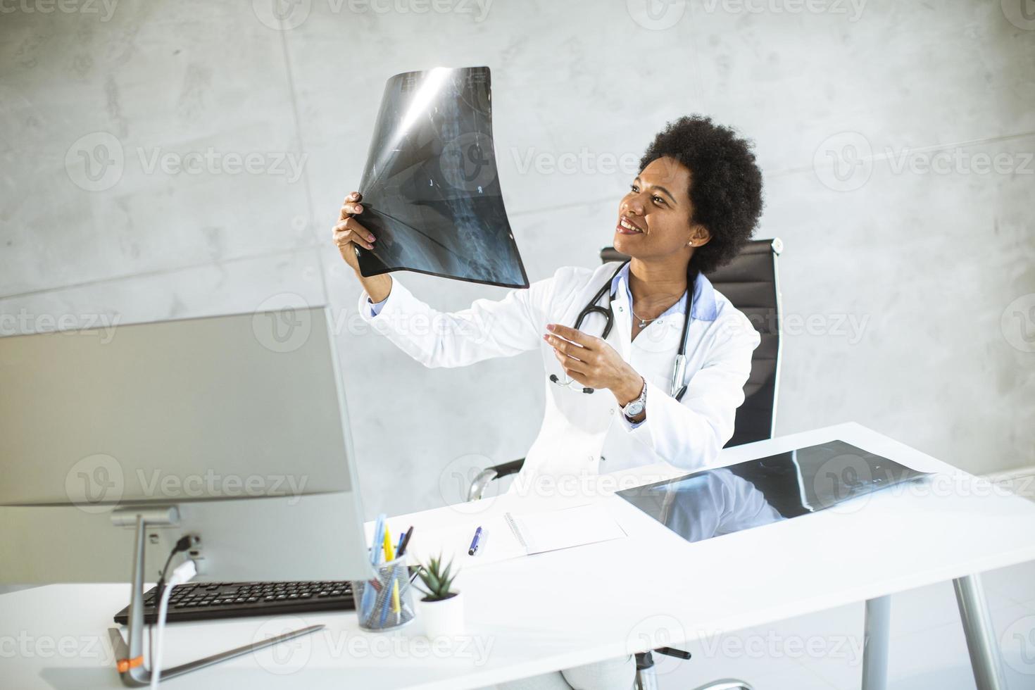 Arzt hält eine Röntgenaufnahme in einem Büro foto