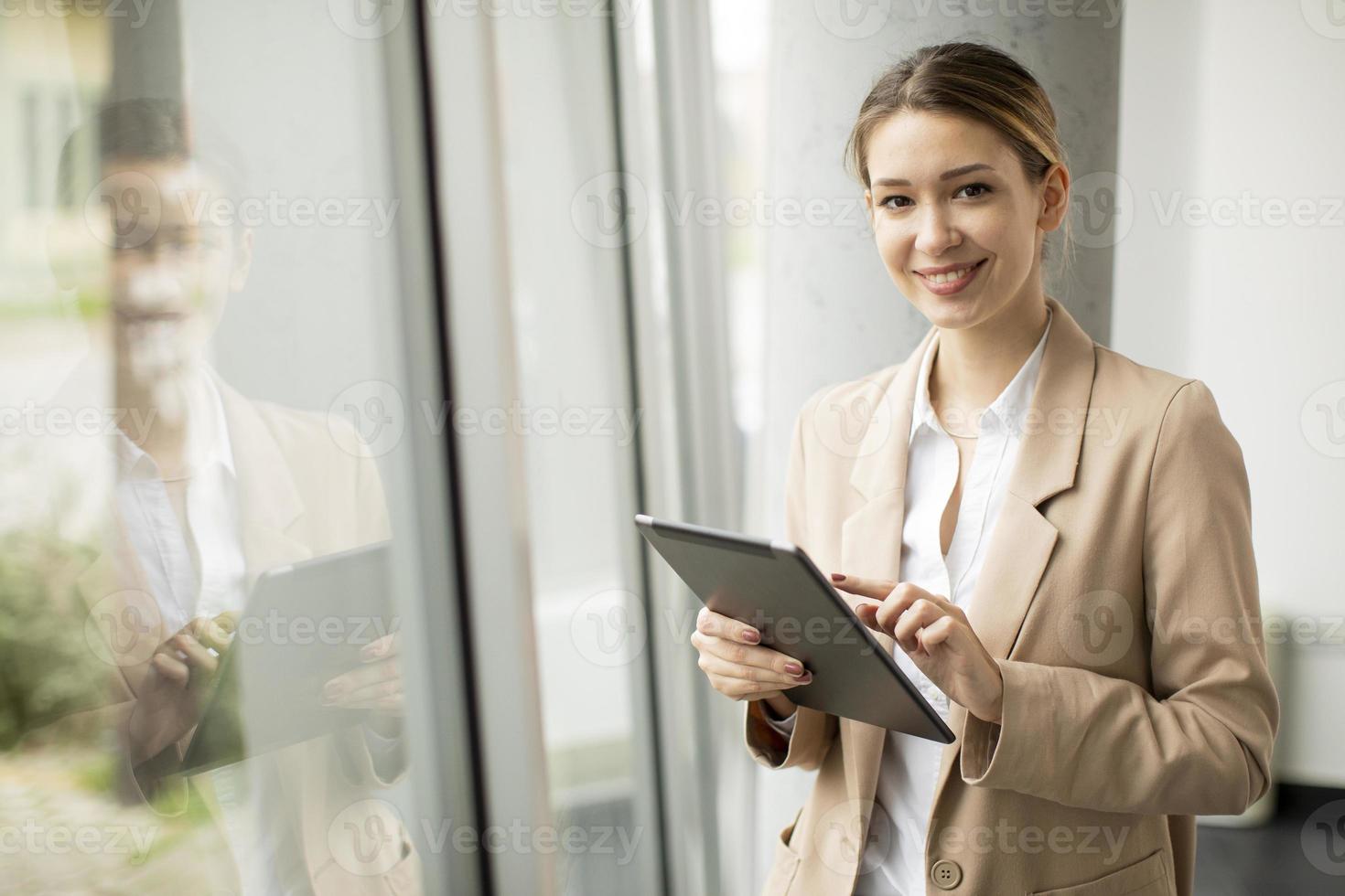 Frau, die Tablette im modernen Büro hält foto