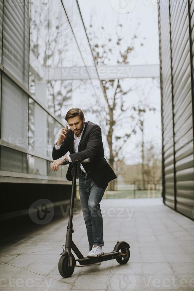 Mann telefoniert mit einem Roller foto