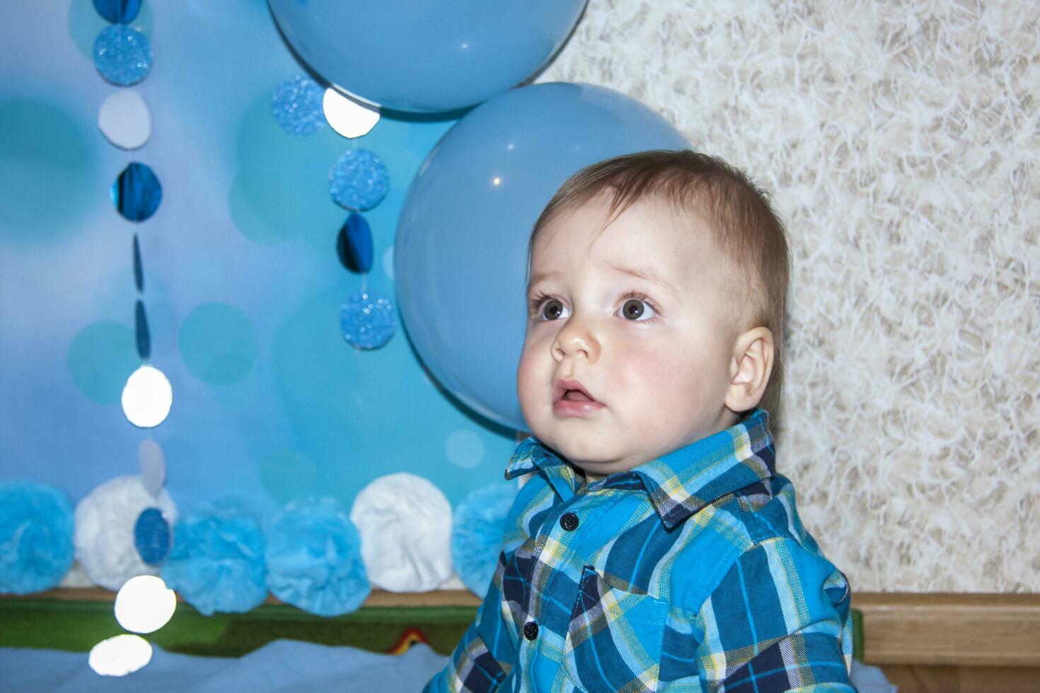 ein schön Baby ist feiern seine zuerst Geburtstag. Porträt von das Baby. ein Junge im ein Blau Hemd unter Luftballons und Geschenke. foto