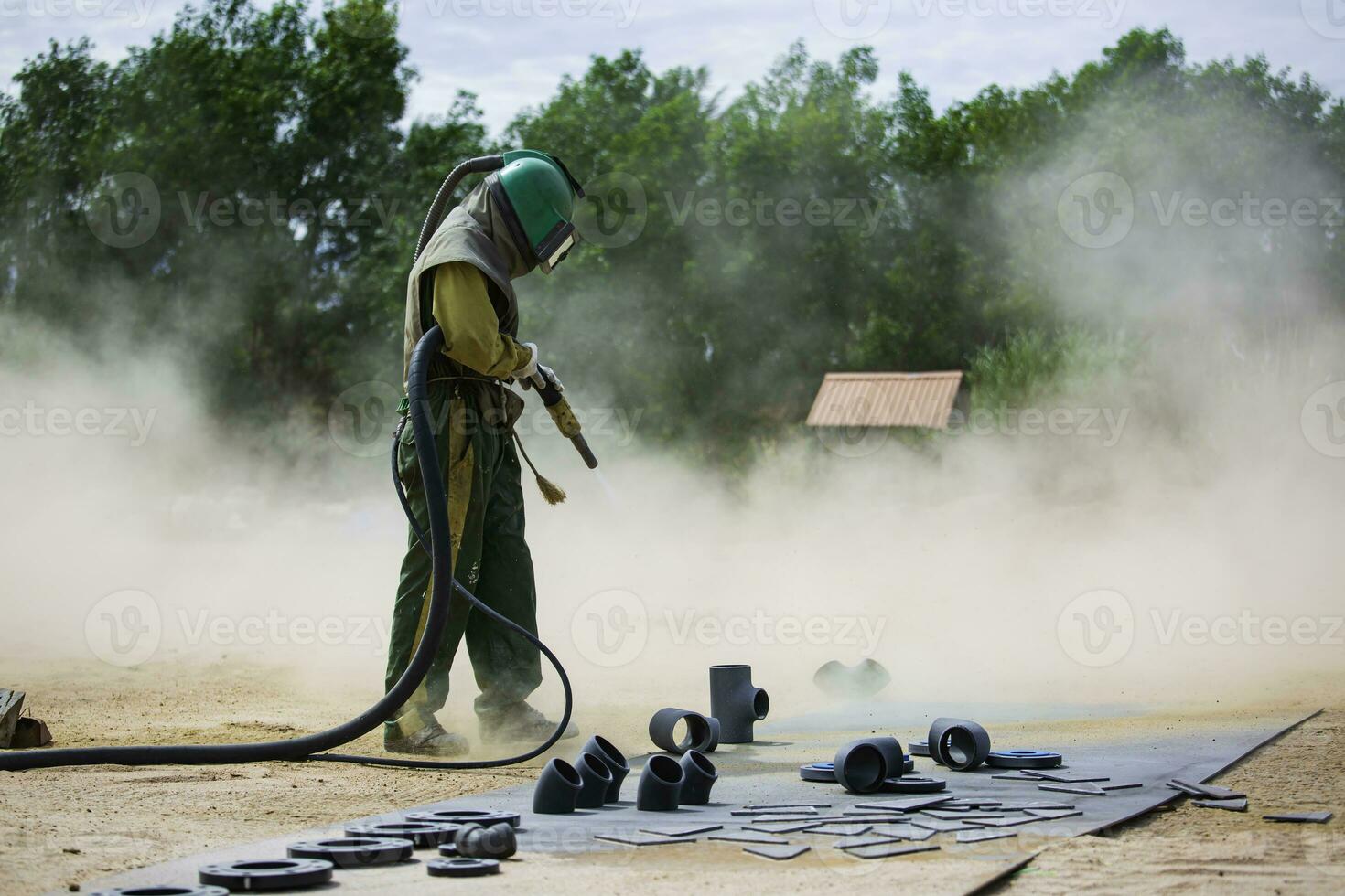 männlich Arbeiter Sand Strahlen Prozess Reinigung Pipeline Oberfläche foto