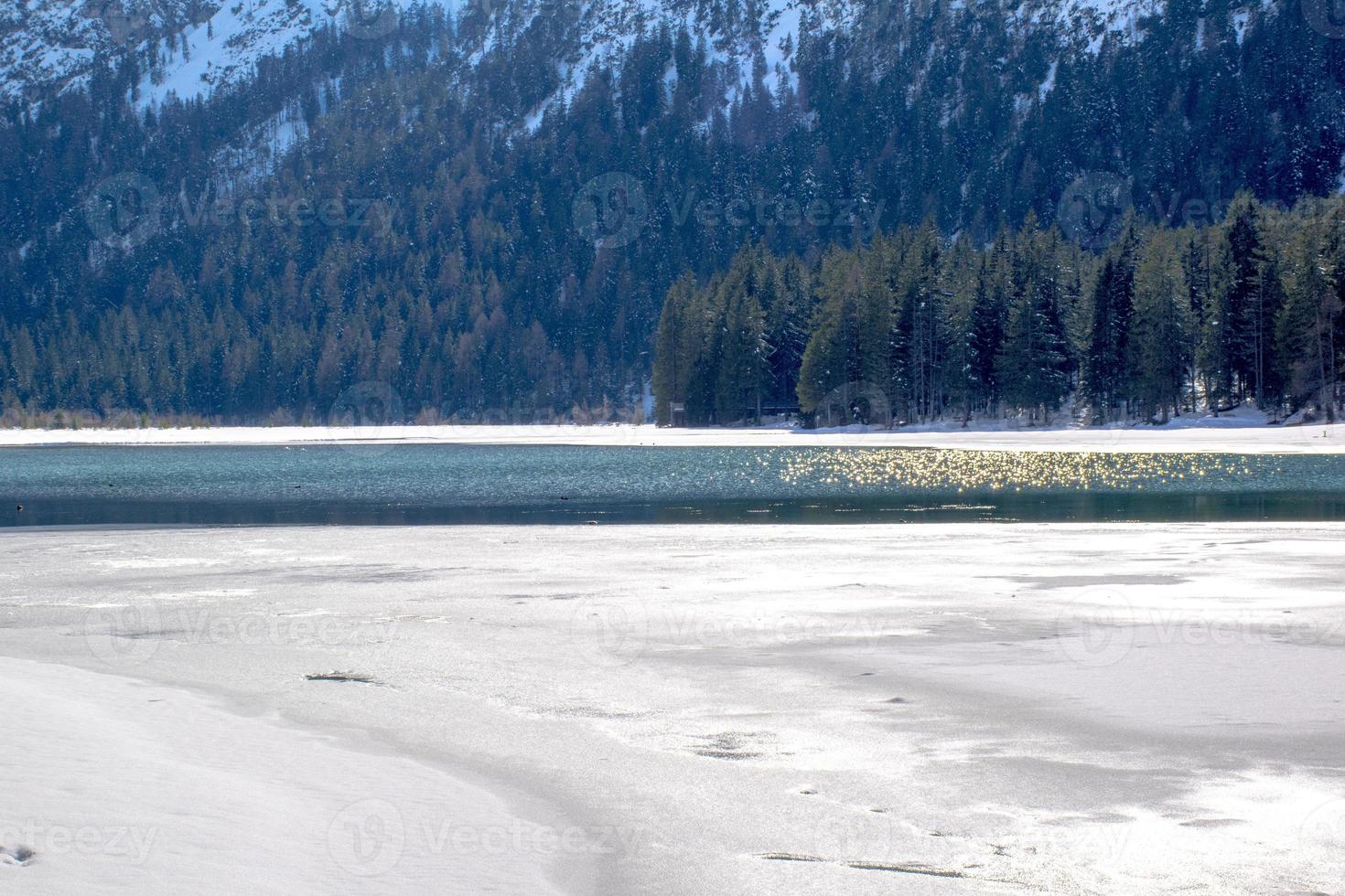 Eis schmilzt auf dem Dolomitsee von Dobbiaco foto