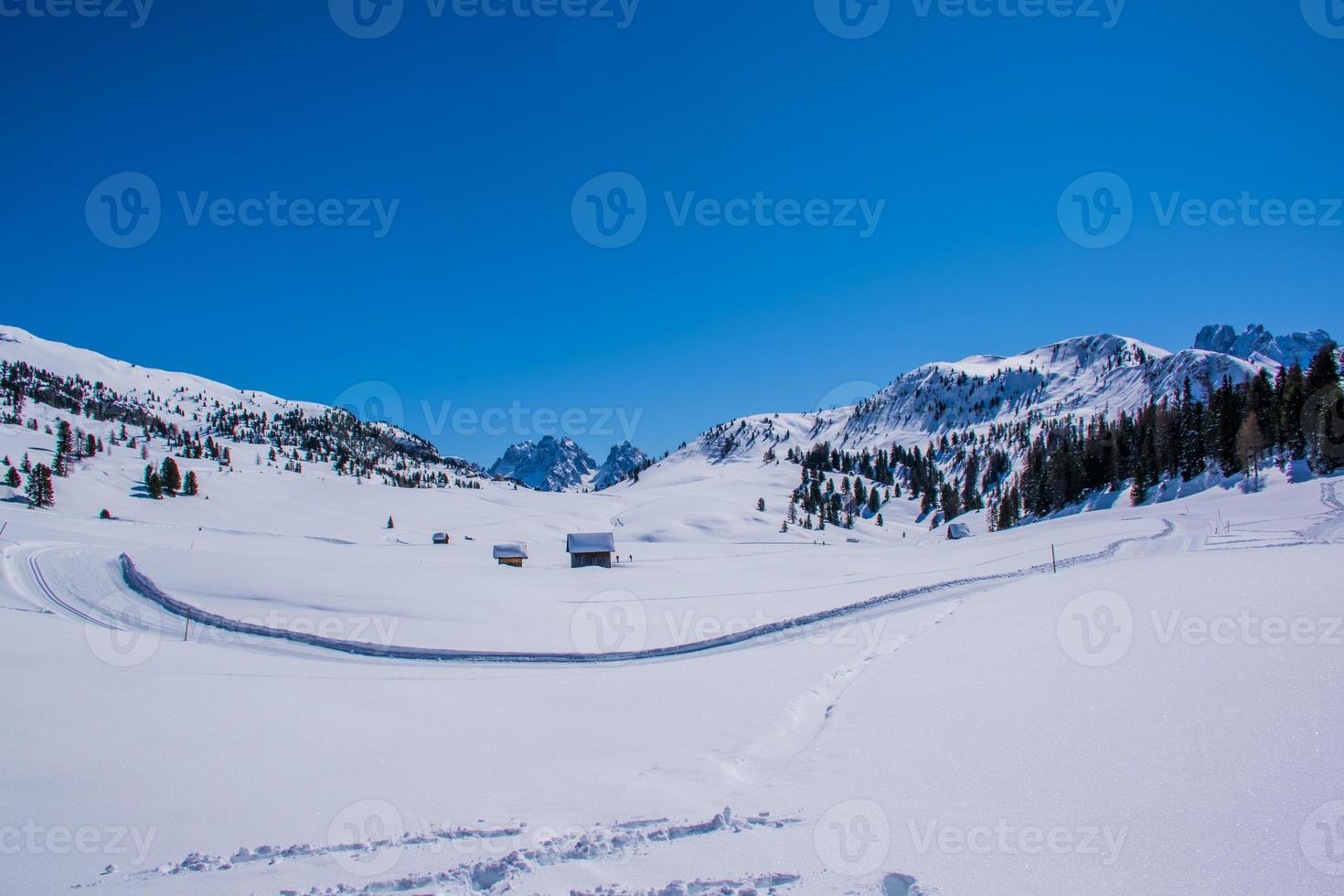 schneebedeckte Dolomiten und Hütten foto