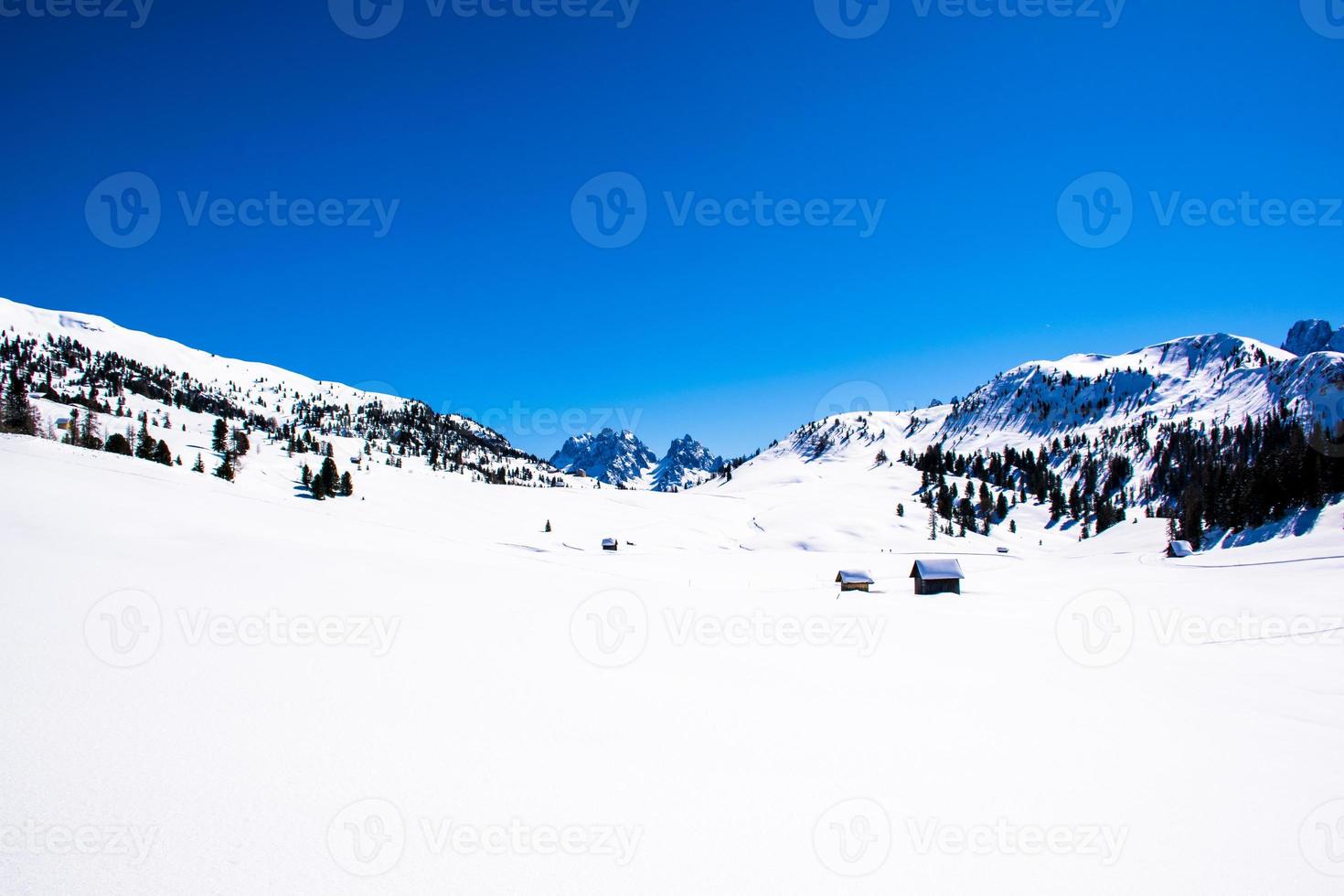 Landschaft mit Schnee und Holzhütten foto