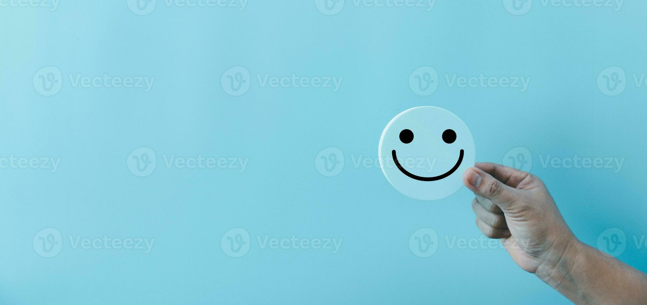 Frau Hand halten glücklich Gesicht Lächeln Gesicht Symbol auf runden Blau Objekt. Kunde Erfahrung und Bedienung mit Befriedigung Konzept. positiv Denken, mental Gesundheit Bewertung, Welt mental Gesundheit Tag. foto