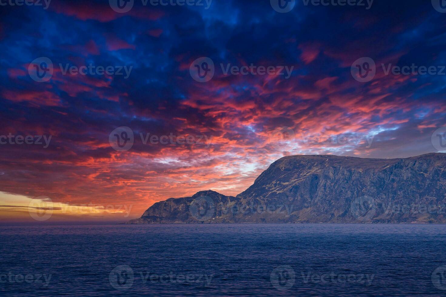 Aussicht von das Meer zu das Westen Kap im Norwegen beim Sonnenuntergang mit Sonne Strahlen und schwer Wolken foto