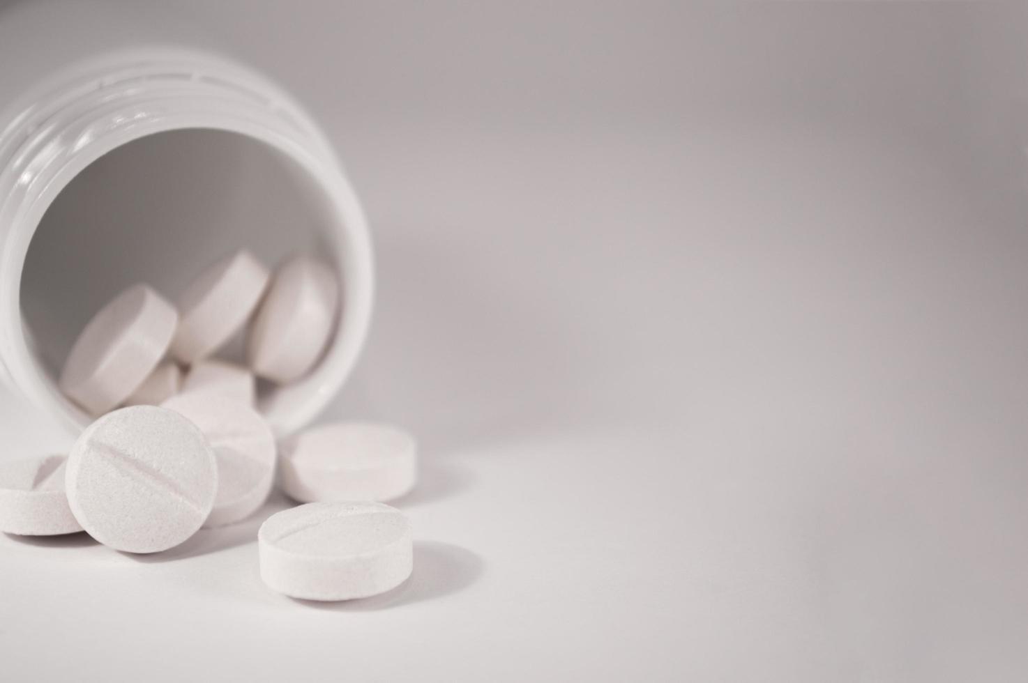 weiße medizinische Pillen und Tabletten mit Flasche foto