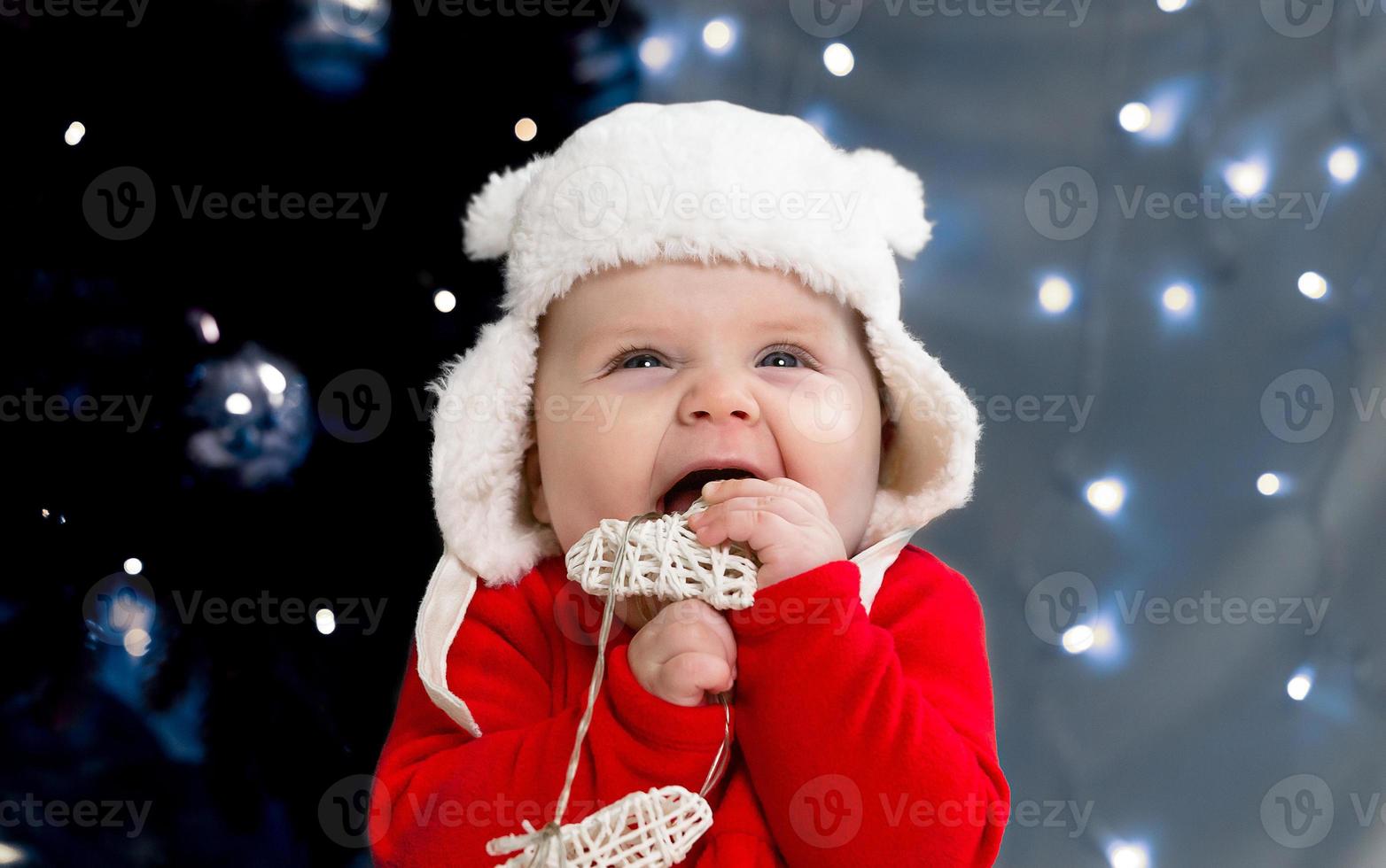 Weihnachtskind lächelt und hält eine Girlande mit Herzen foto