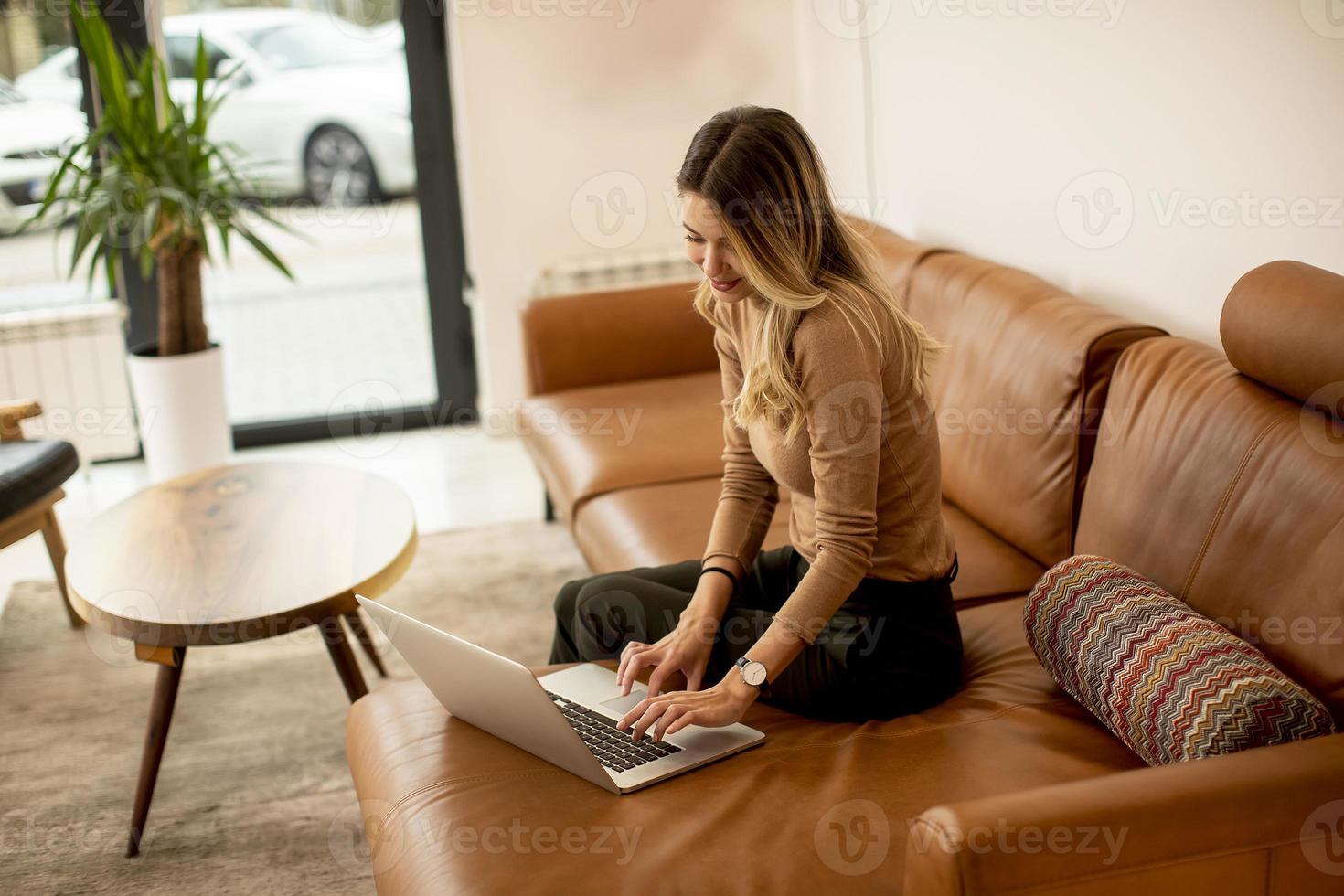junge schöne Frau mit einem Laptop zu Hause foto