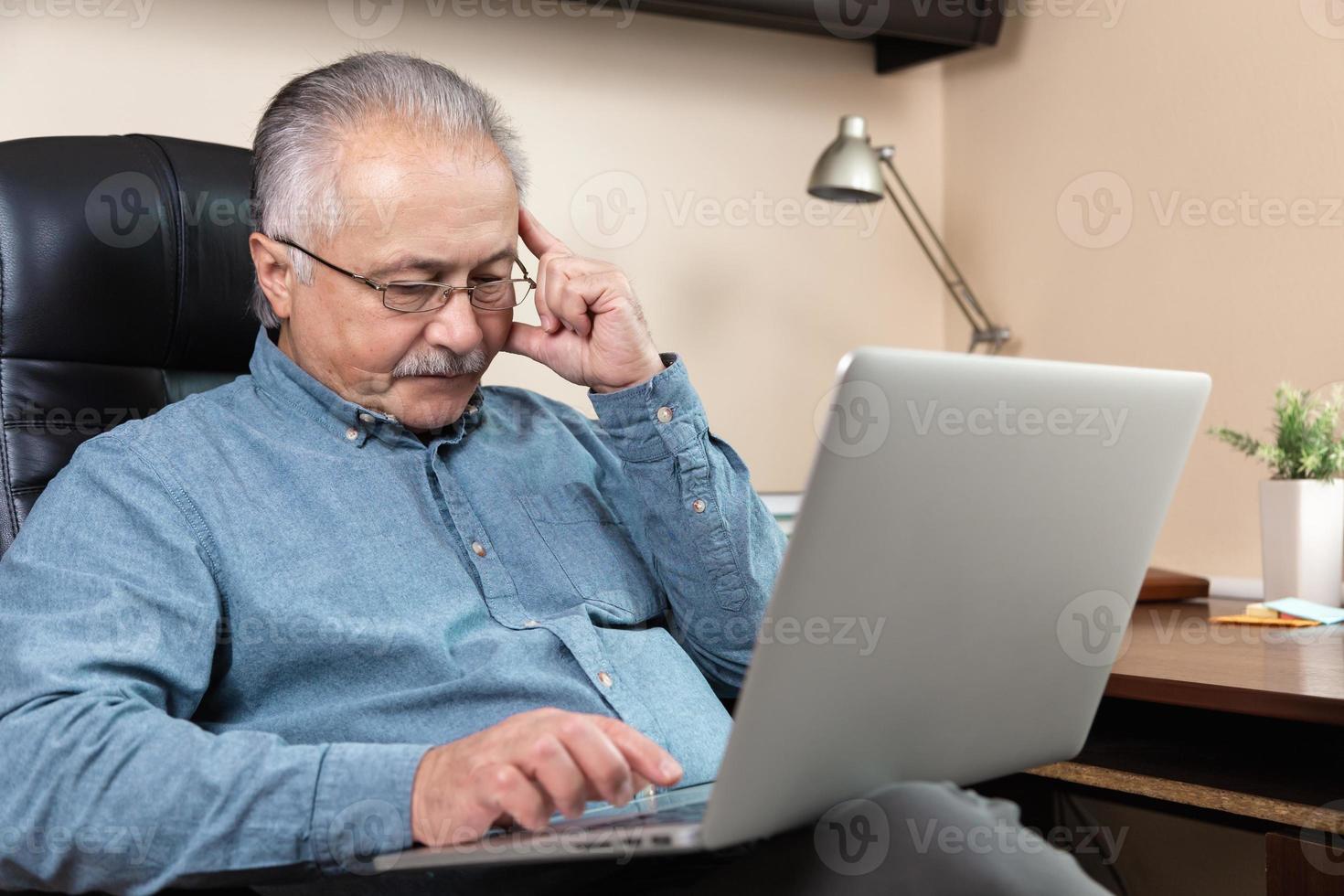 nachdenklicher älterer Geschäftsmann arbeitet zu Hause foto