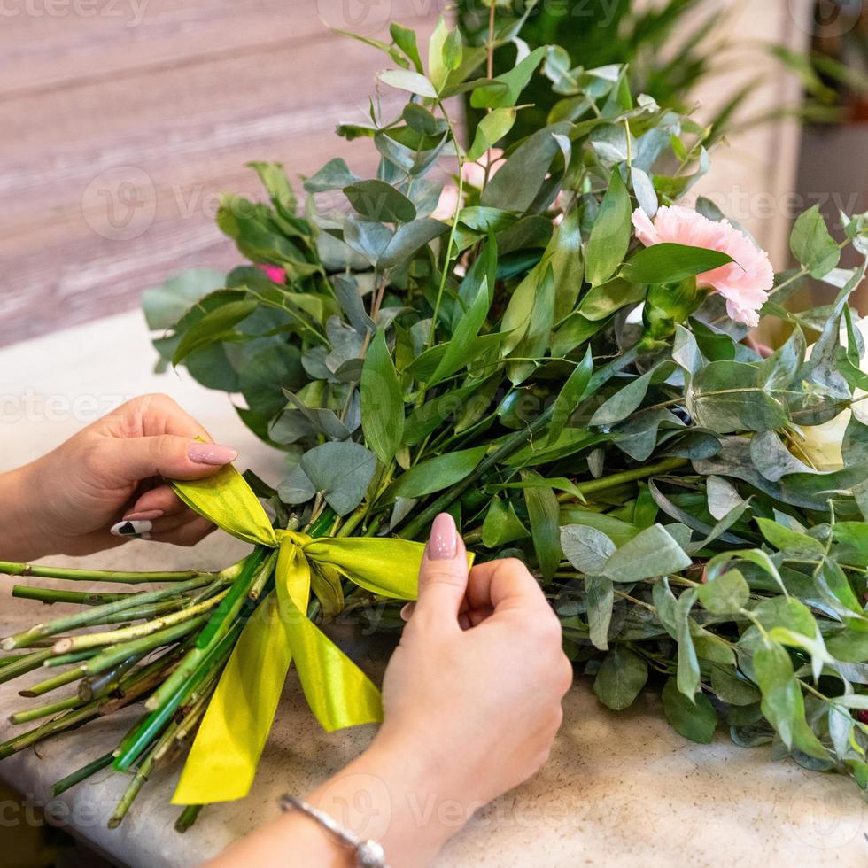 Floristenfrau, die Blumenstrauß im Laden macht foto