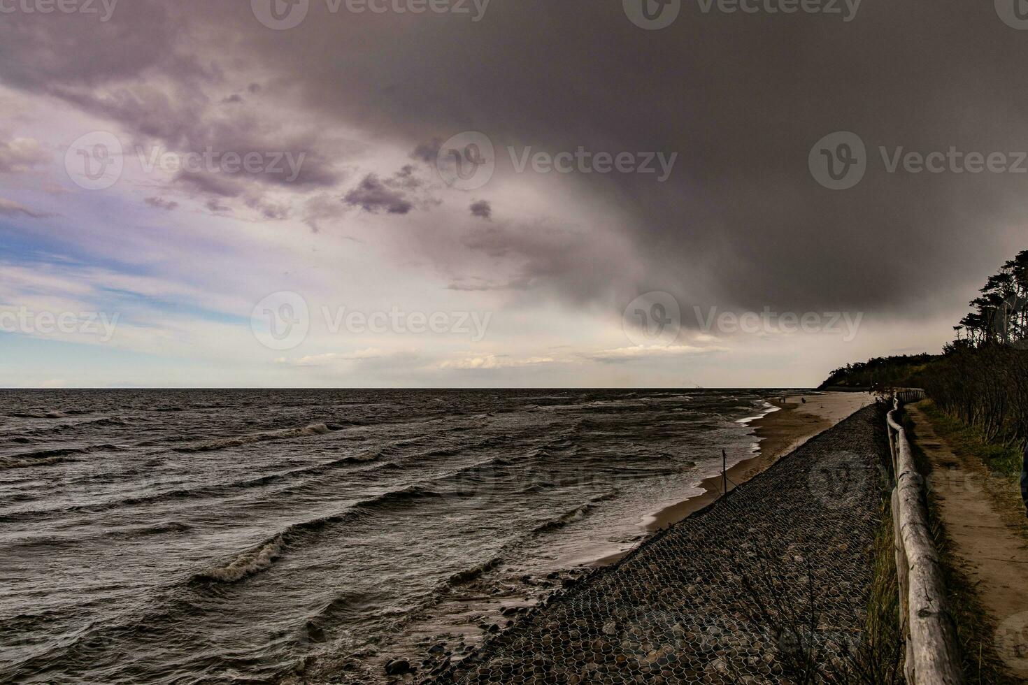 Strand Landschaft mit Wasser Wellen, Strand und drohend dunkel bedrohlich Sturm Wolke im Frühling foto