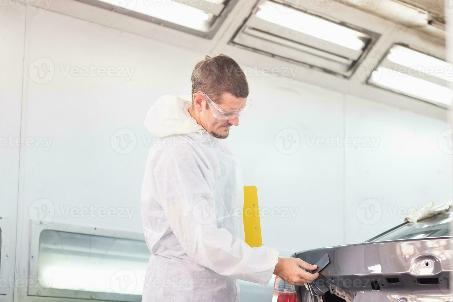 Handwerker Überprüfung Schatten Karten zum Auto malen, Arbeiter Maler Überprüfung Farbe passend Vor malen, Garage Gemälde Auto Bedienung Reparatur und Instandhaltung foto