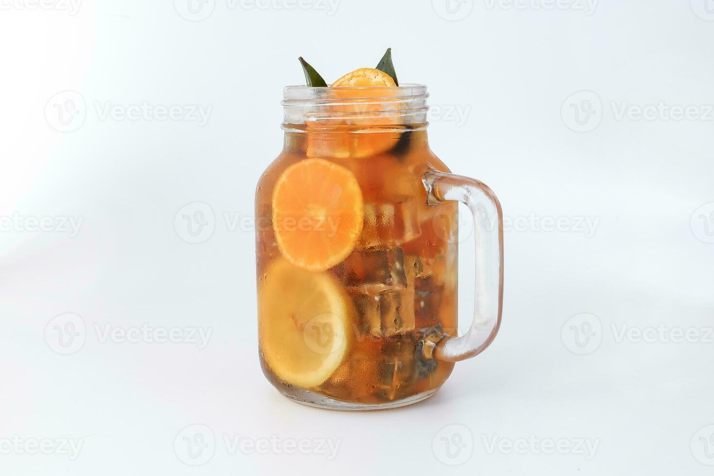 Flüssigkeit Eis Zitrone Orange Tee mit Scheibe Grün Blatt Zimt Stock im transparent Glas Krug Becher auf Weiß Hintergrund foto