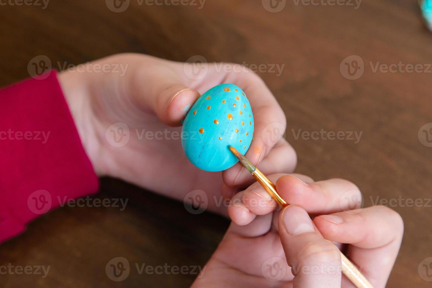 Nahaufnahme von Frauenhänden, die ein Osterei färben foto