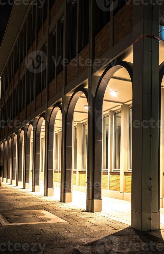 geschwungene Arkade eines mehrstöckigen Hauses in der Nacht foto