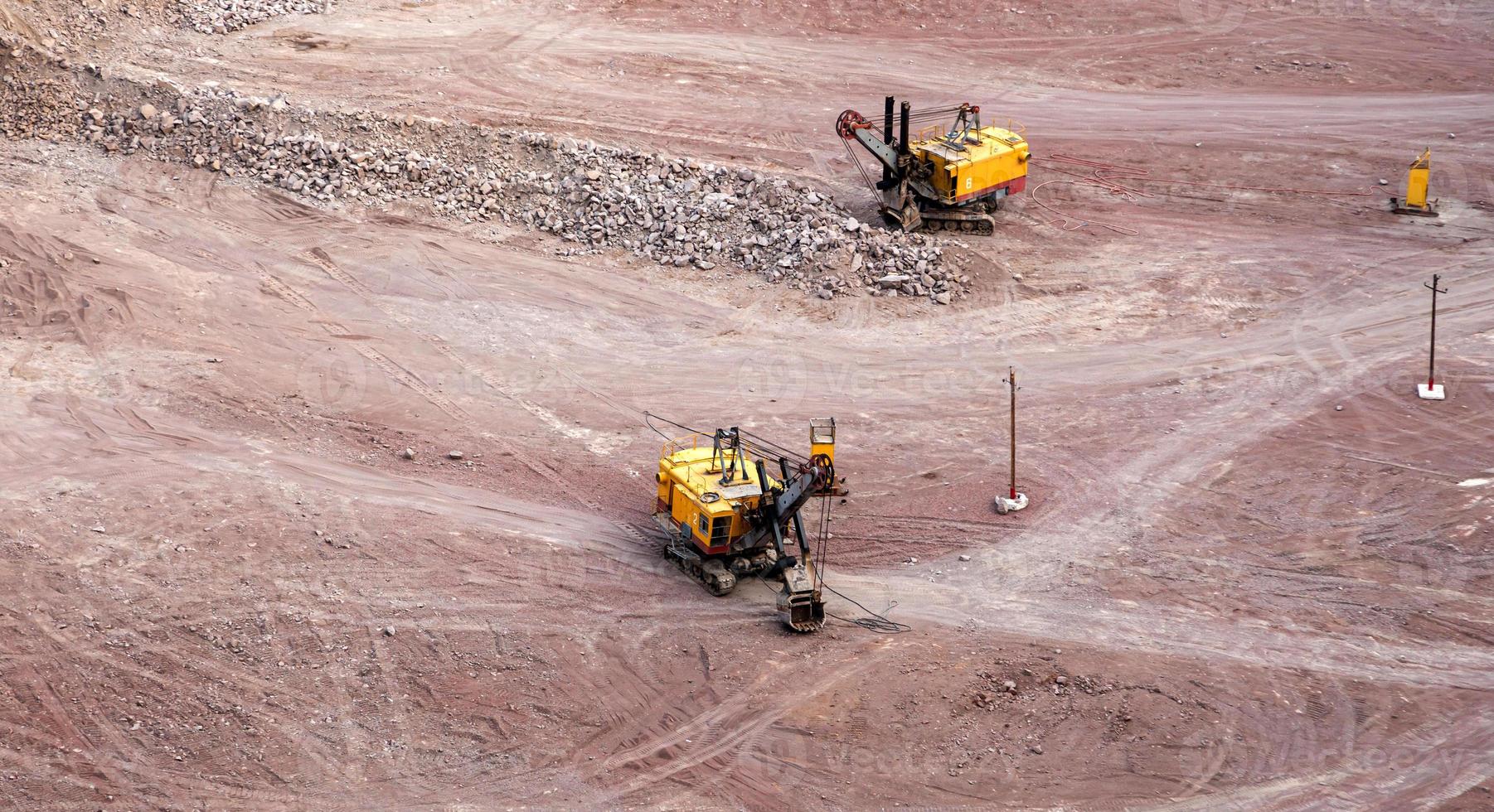 Bagger in einem Steinbruch, der Steine gewinnt und bewegt foto