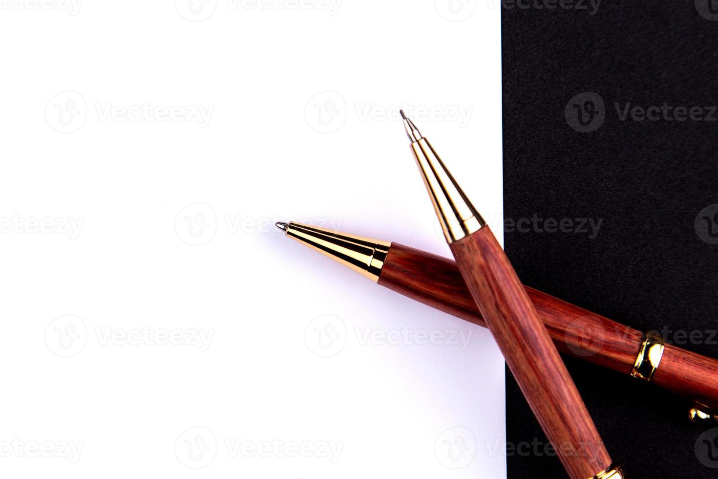 Luxusstift und Druckbleistift in Holz und Gold mit einem weißen Blatt Papier foto