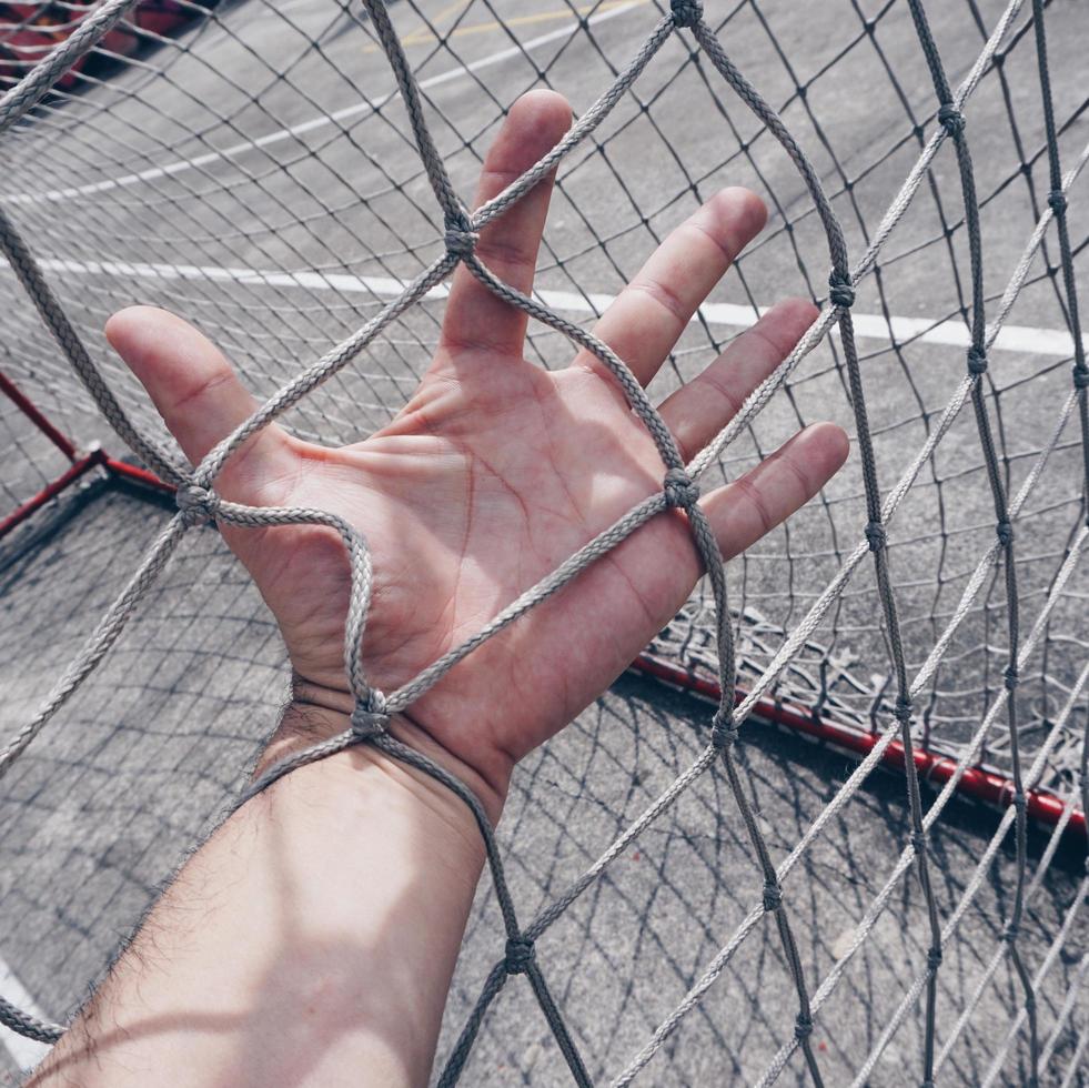 Hand berührt ein Seilnetz foto