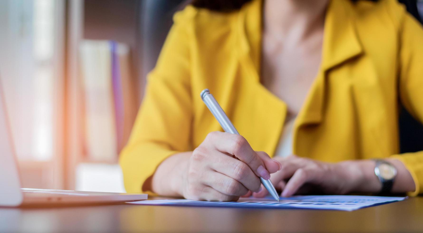 Hand der Geschäftsfrau unterzeichnet einen Vertrag über geschäftliche Zusammenarbeit foto