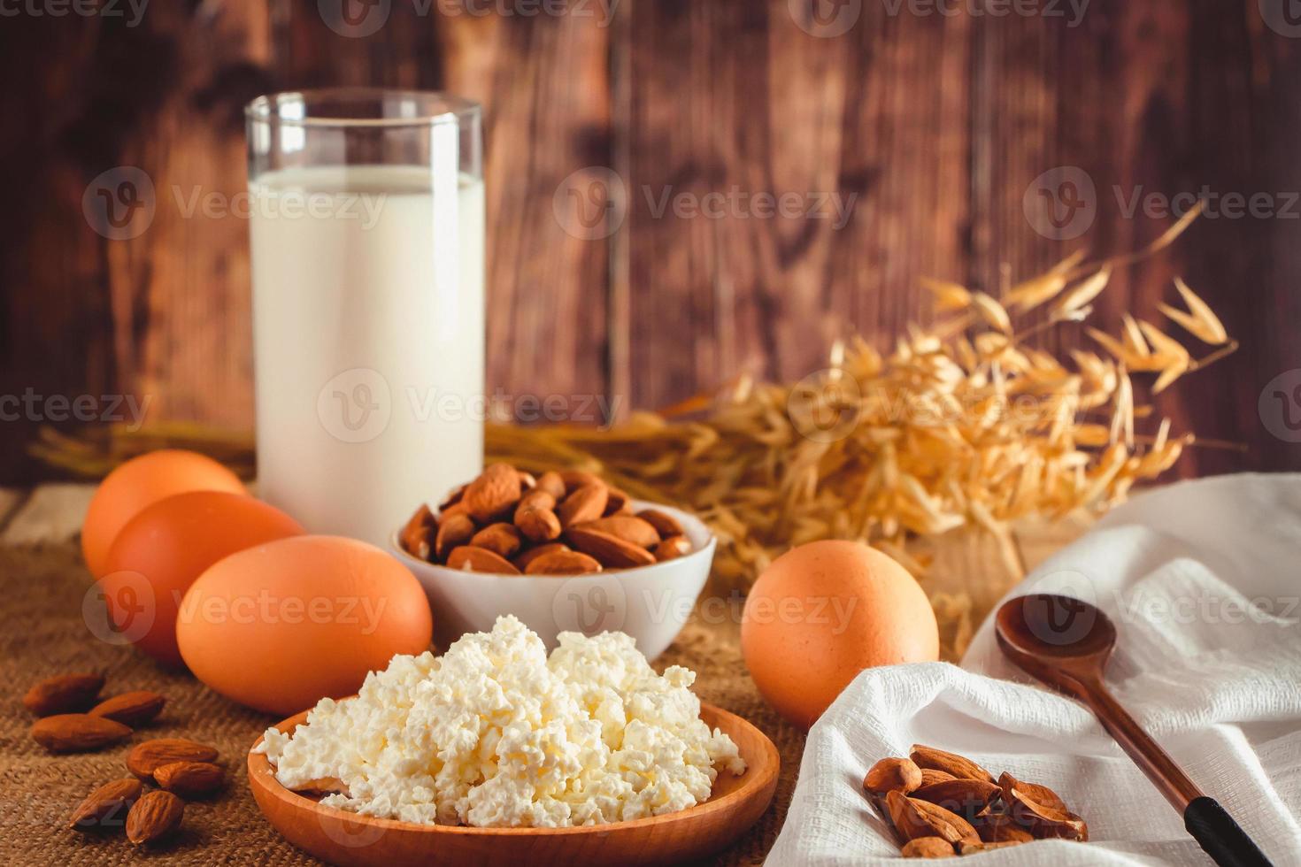 Hüttenkäse Eier Nüsse und Milch auf einem hölzernen Hintergrund foto