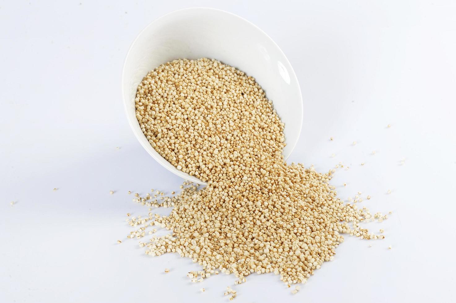 Quinoa, die auf einem weißen Hintergrund knallt foto