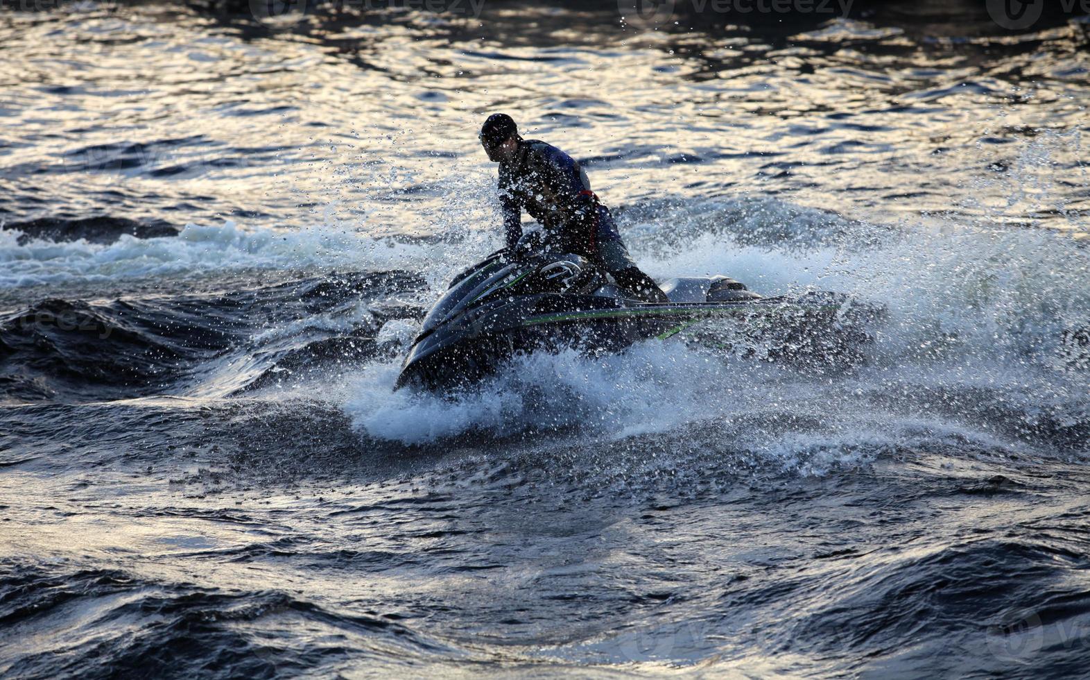 Jetski mit hoher Geschwindigkeit hebt eine große Welle foto