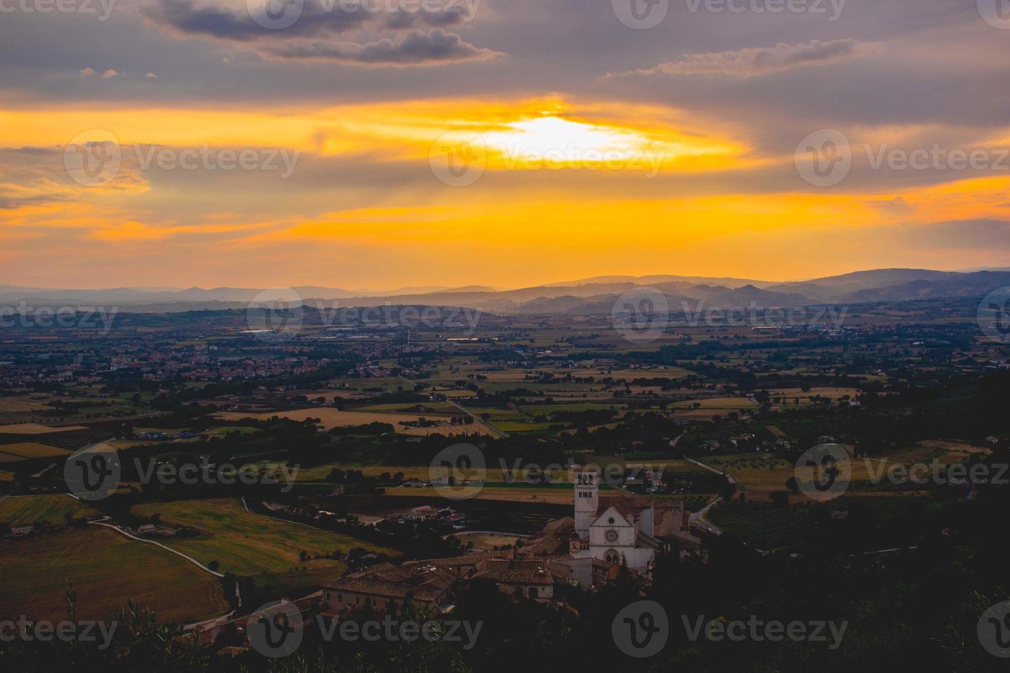 Basilika von San Francisco in Assisi mit einem herrlichen Sonnenuntergang foto