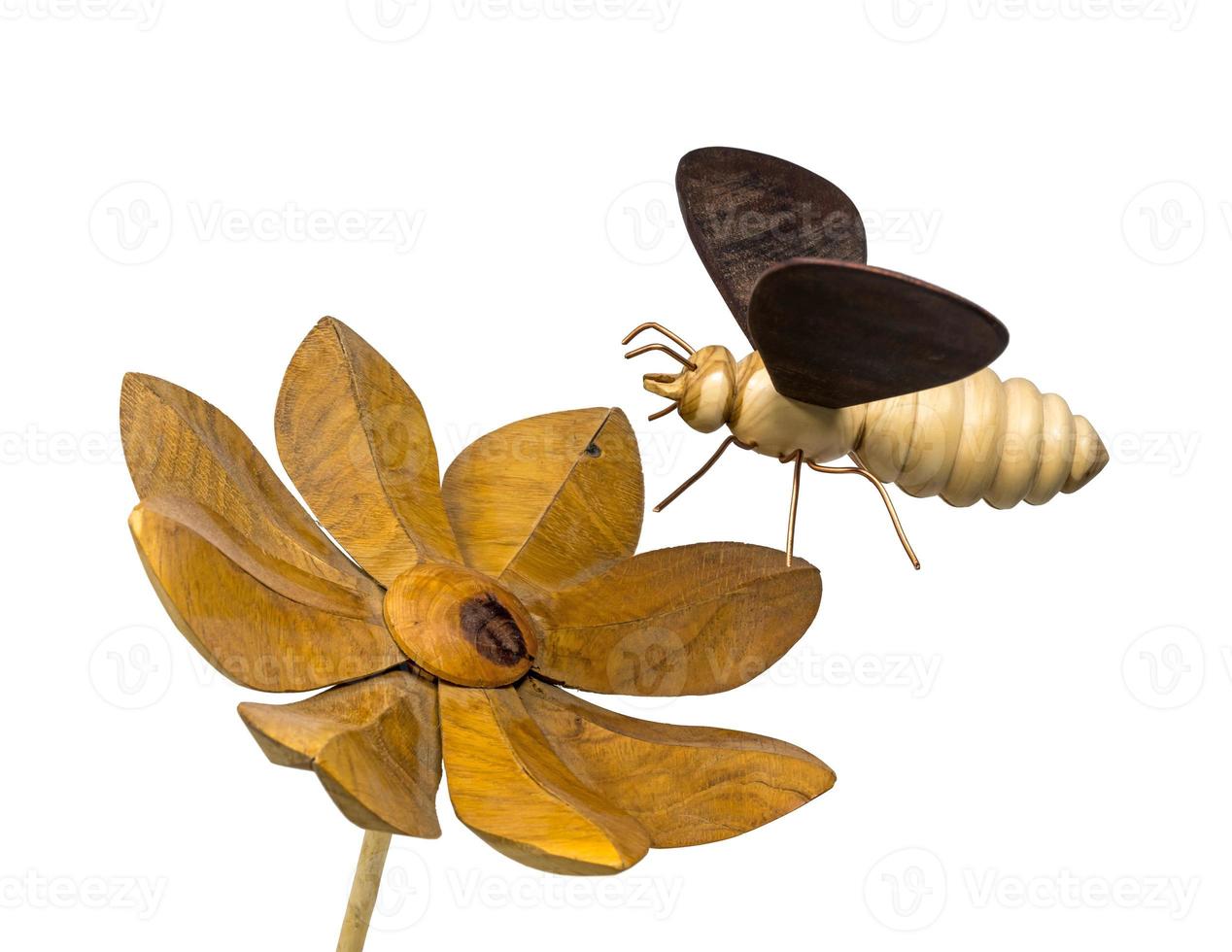 Modell einer Holzbiene fliegt auf eine Holzblume zu foto