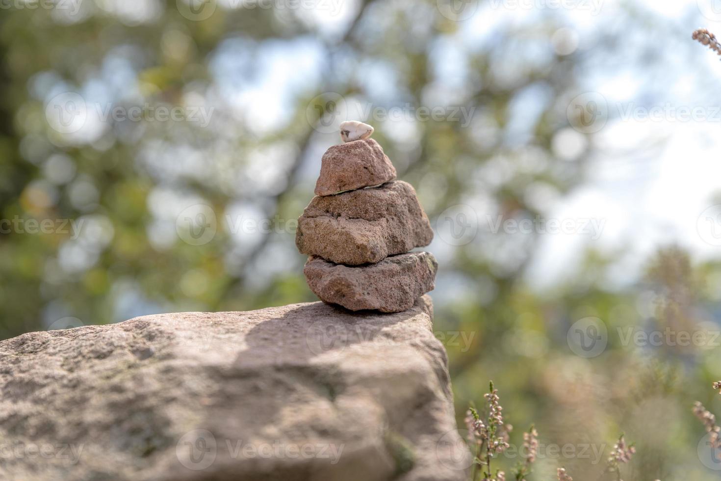 Turm aus gestapelten Sandsteinen auf dem Waldboden foto