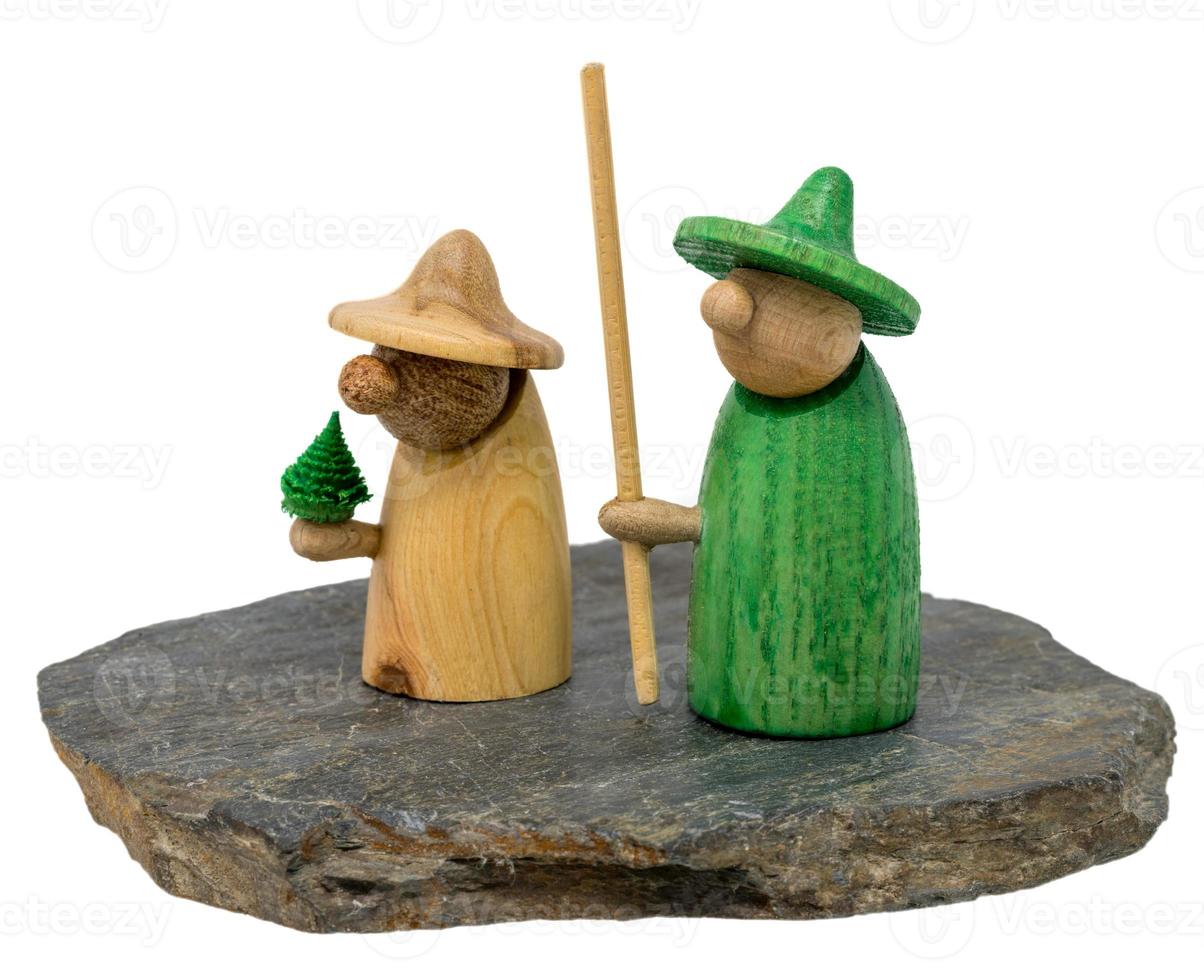 Zwei hölzerne Weihnachtsfiguren stehen auf einem dunklen Holzbrett foto