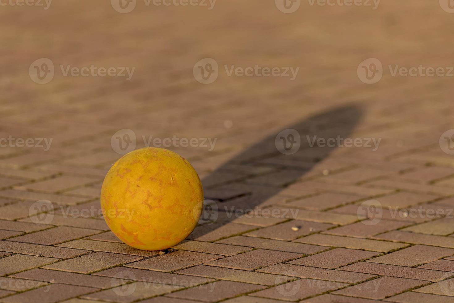 gelber Kinderball liegt auf einem gepflasterten Platz foto