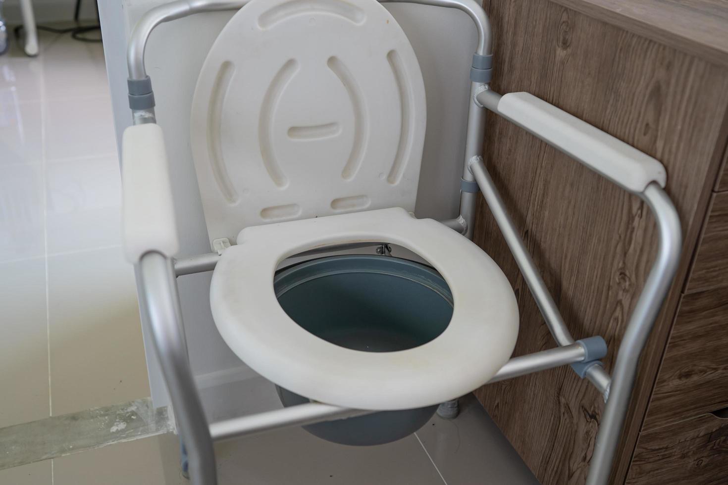 Kommodenstuhl oder mobile Toilette können im Schlafzimmer oder überall für ältere alte behinderte Menschen oder Patienten im Krankenhaus gesundes starkes medizinisches Konzept bewegen foto