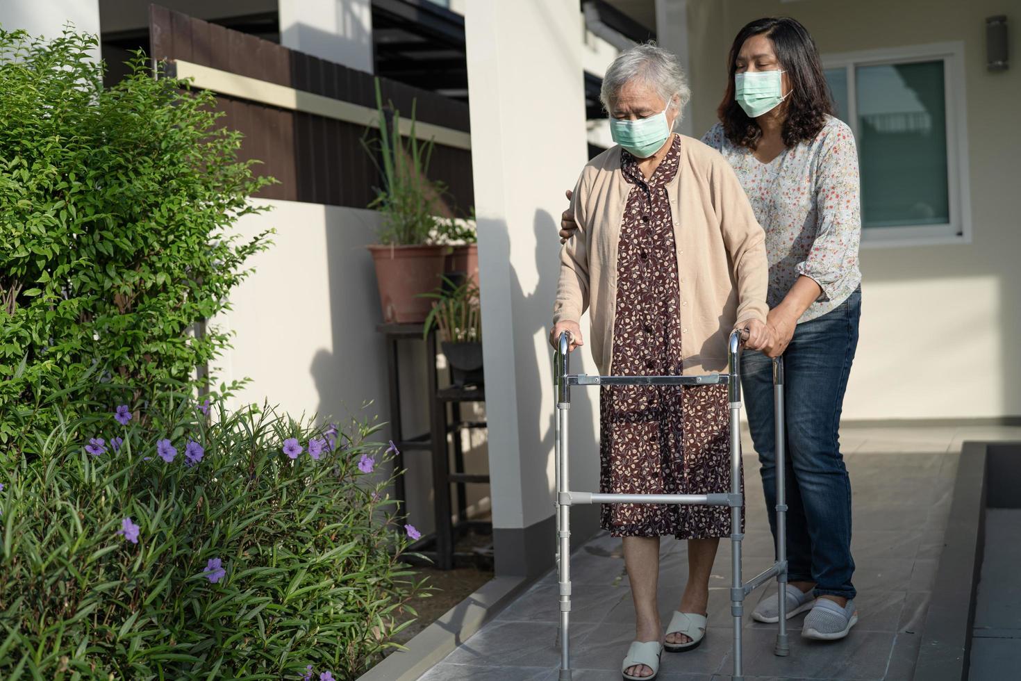 asiatische ältere oder ältere alte Dame Frau gehen mit Walker und tragen eine Gesichtsmaske zum Schutz der Sicherheitsinfektion covid 19 Coronavirus foto