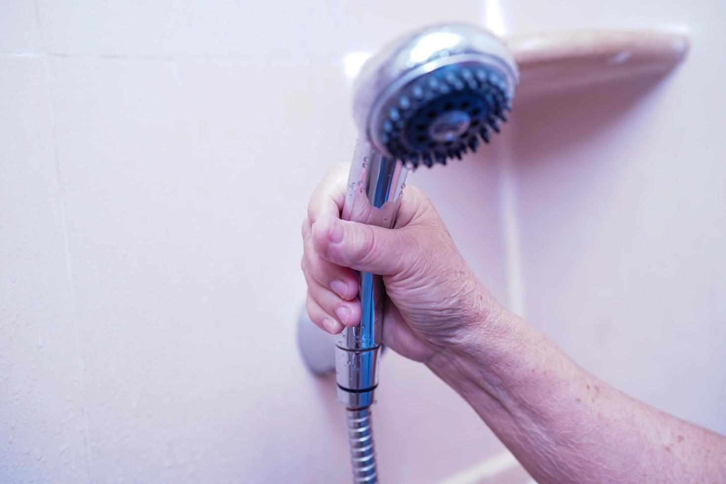 asiatische ältere oder ältere Patientin der alten Dame, die Dusche im Toilettenbad hält, um in der Krankenstation zu baden foto